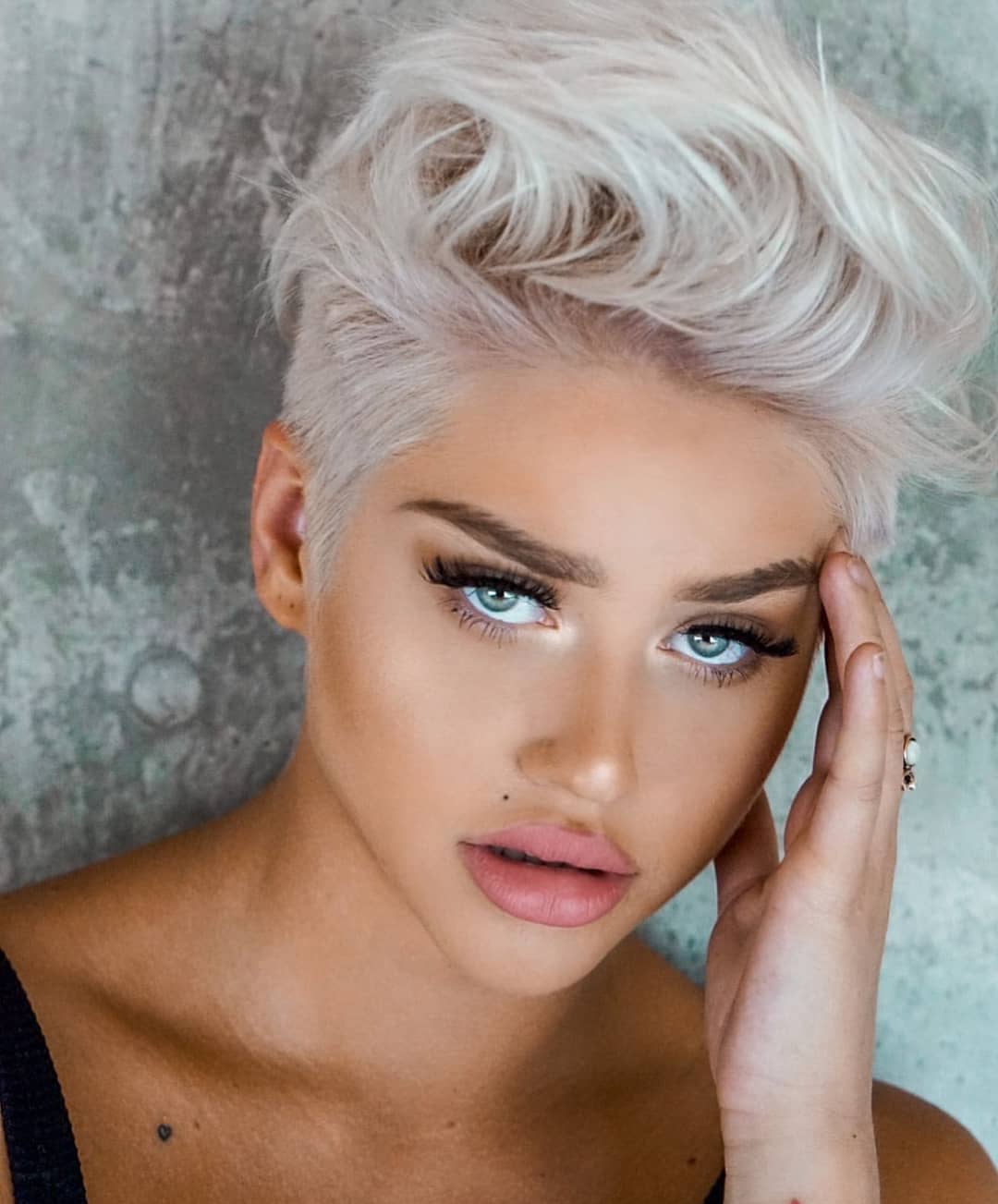 Pixie cut biondo platino con ciuffo fintamente spettinato all’indietro